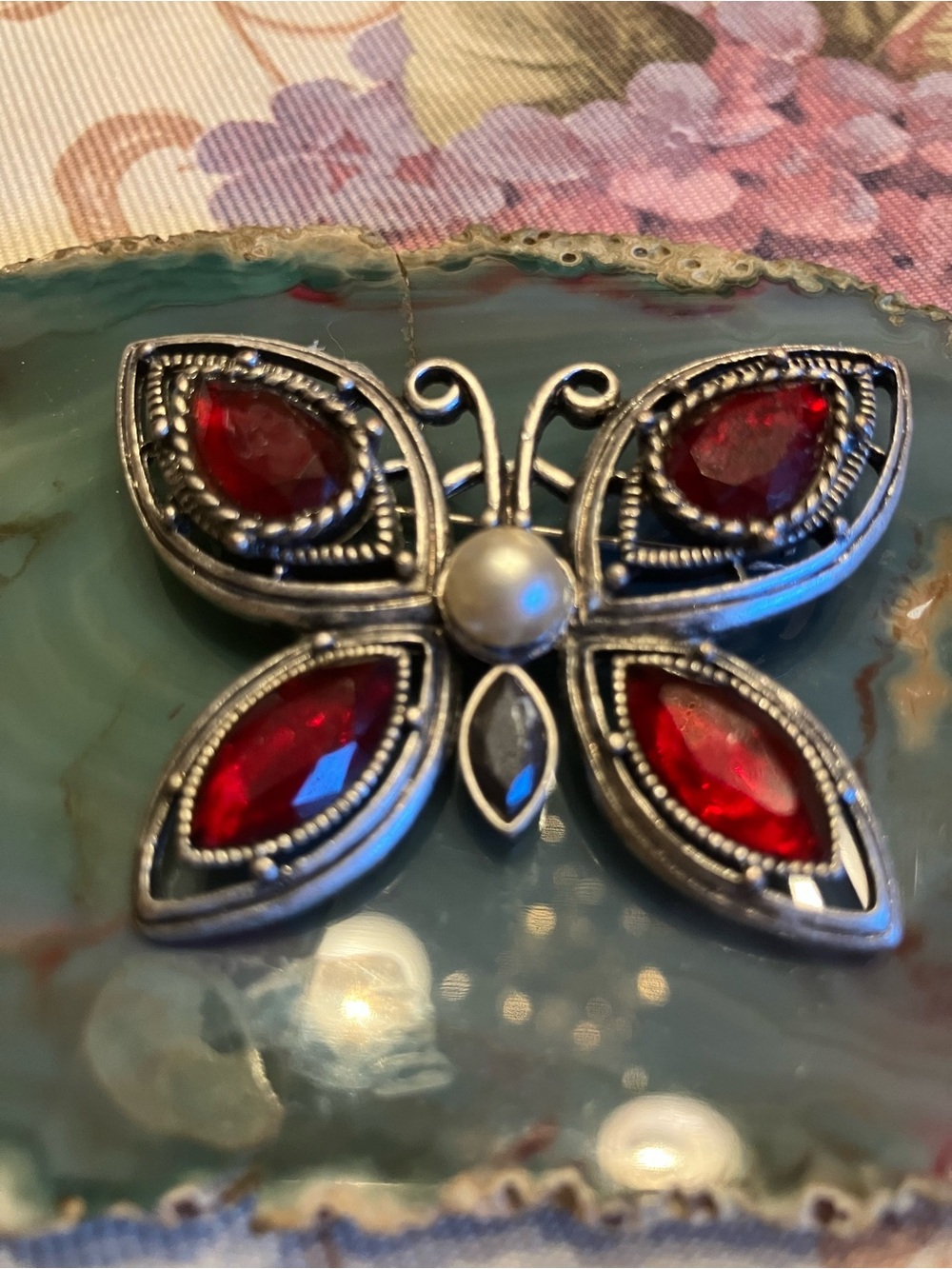 Vintage Silver-tone brooch featuring striking red crystal faceted marquee stones